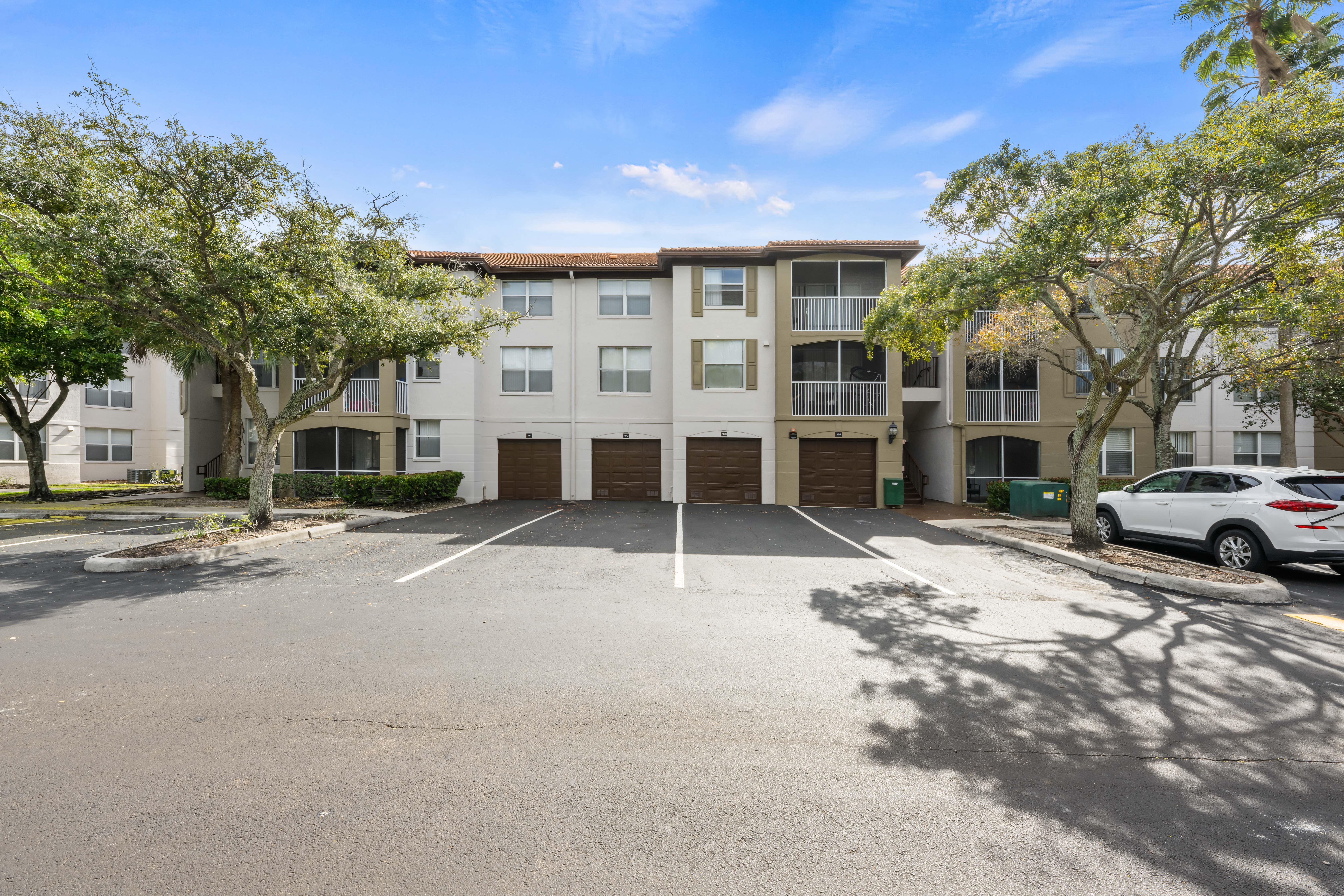 A white building with a parking lot in front.